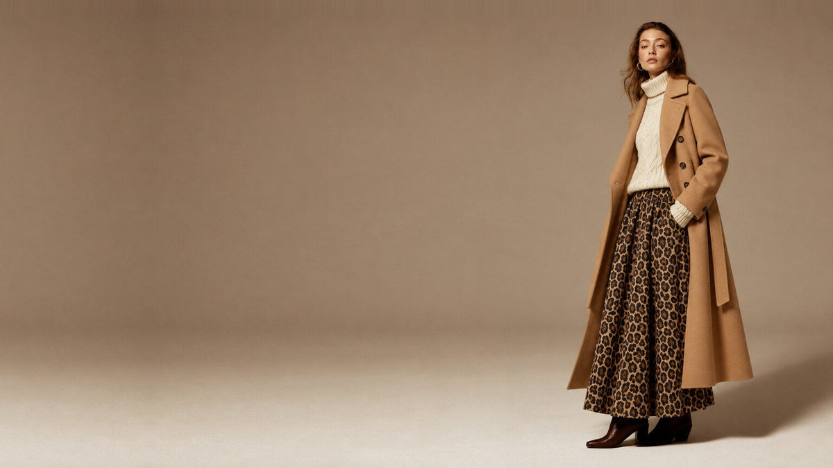 Model in a camel longline coat, cream cable knit turtleneck and leopard print maxi skirt